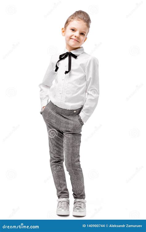Beautiful Little Girl in White Shirt and Gray Pants Standing Near White ...