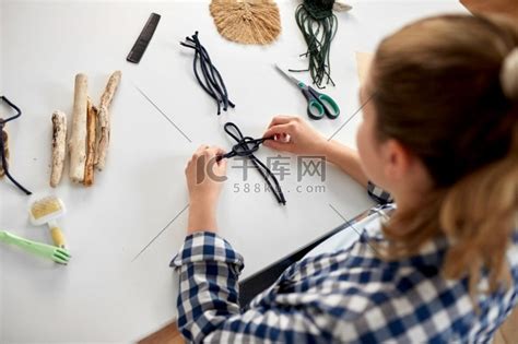 DIY，手工和爱好概念-女人在家里的桌子上制作马克龙工艺品和打结绳索的特写。做松糕和打结绳索的女人高清摄影大图-千库网