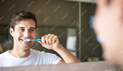 Brushing teeth man and cleaning in a bathroom at home for oral hygiene ...