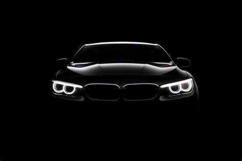 Front view dark silhouette of a modern luxury black car isolated on black background. 23977547 ...
