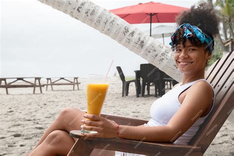 Premium Photo | Woman drinking a juice on the beach during summer vacation