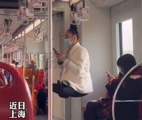 头发系扶手上 女子地铁凌空盘坐玩手机 乘客看傻 - 万维读者网