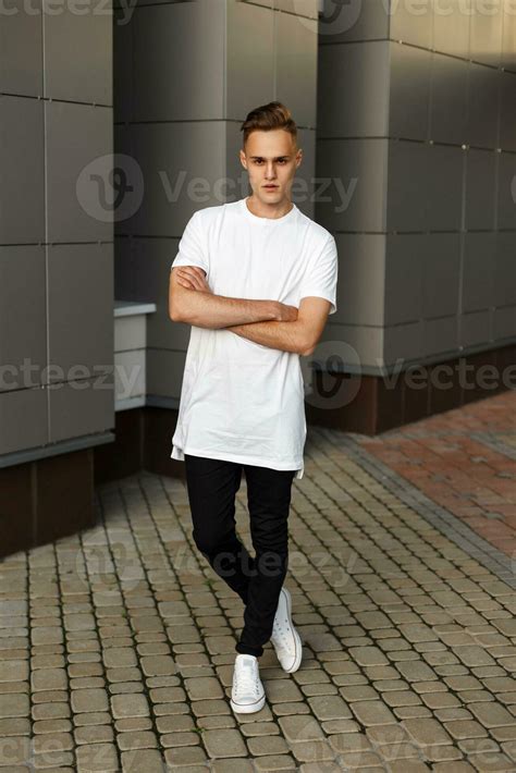 Handsome young hipster stylish man in white shirt, black pants and ...