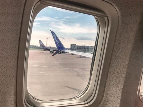 a small tempered glass window on board an aircraft. passengers look at ...