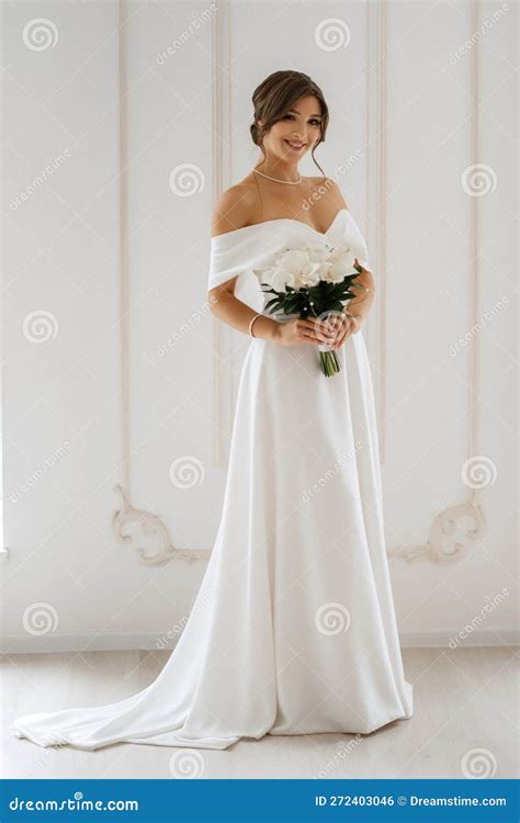 Brunette Bride in a Tight Wedding Dress in a Bright Studio Stock Photo - Image of room, inside ...