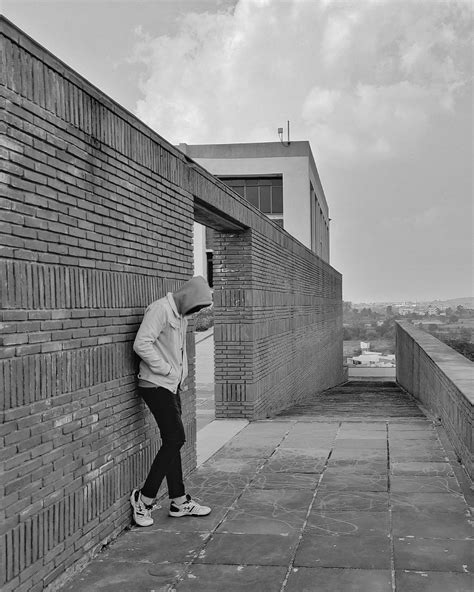 Man in Jacket and Hood Standing near Wall · Free Stock Photo