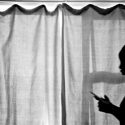 Shadow of woman while using phone on curtain | Premium Photo