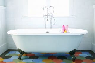 a bathtub with two toothbrushes in it on a colorful tile floor next to ...