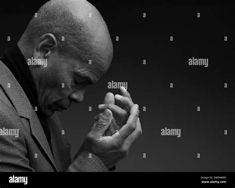 black man praying to god with hands together Caribbean man praying with ...