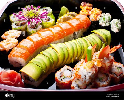 Different sushi rolls on a black plate Stock Photo - Alamy