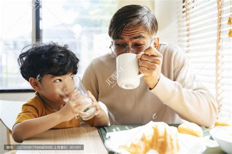 小男孩和爷爷一起喝饮料，他早上喝牛奶，爷爷喝咖啡。,摄影素材,汇图网www.huitu.com