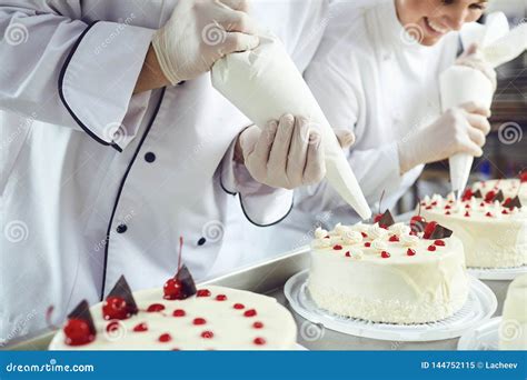 Two Pastry Chefs Decorate a Cake from a Bag in a Pastry Shop Stock Image - Image of baked ...