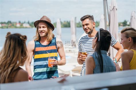 快乐的年轻人在沙滩酒吧喝酒和共饮料高清图片下载-正版图片503581528-摄图网