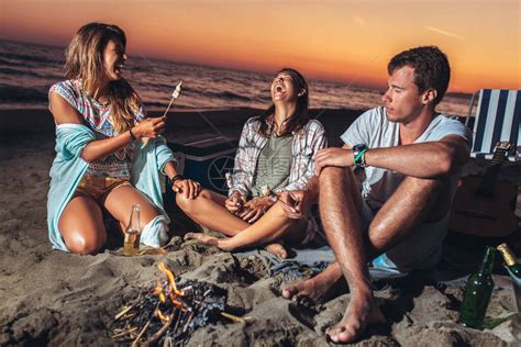 快乐的朋友在沙滩上狂欢与喝酒高清图片下载-正版图片506706807-摄图网