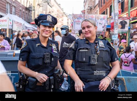 Two smiling NYPD officers pose for the camera in their uniforms ...
