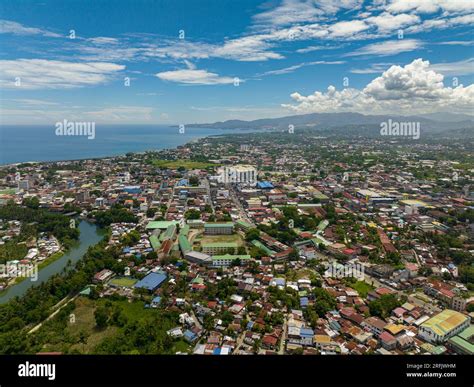 Riverside of Iligan City with buildings and villages.. Blue sky and ...
