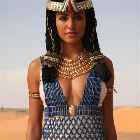 an egyptian woman in blue and white dress with gold jewelry on her head ...