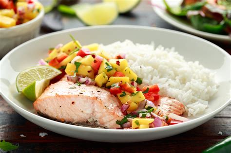 Close-up on salmon fillet with fruit salsa, over rice.