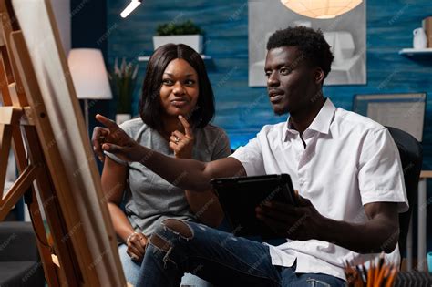 Professional sketching female teacher teaching arts techniques to male ...