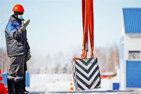 Slinger in helmet works outside signal to lift load up long workflow ...