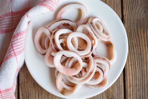 squid rings on white plate, Fresh squid cooked boiled with for food salad on wooden background ...