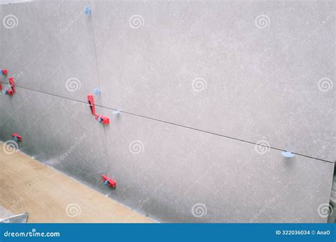 Installation of Porcelain Tiles on the Wall. Tile Leveling System Stock ...