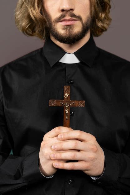 Feche o padre segurando a cruz | Foto Grátis