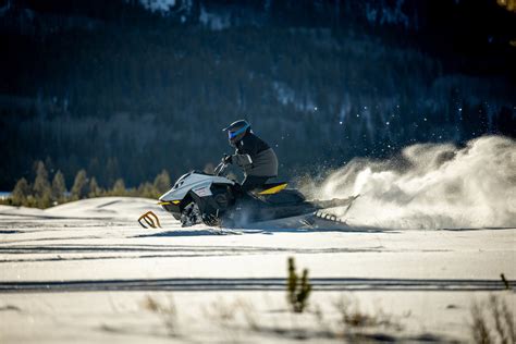 Rider riding up a snowy mountain on the 2027 Ski-Doo Summit