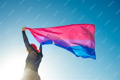Premium Photo | Woman holding the Bisexual Rainbow Flag with the blue sky