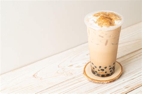 Taiwan milk tea with bubble and cheese burned on wood table | Premium Photo