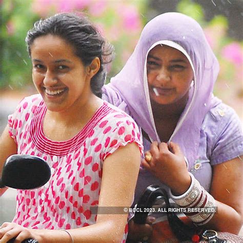 Young girls walking along a road as it rains in Srinagar.