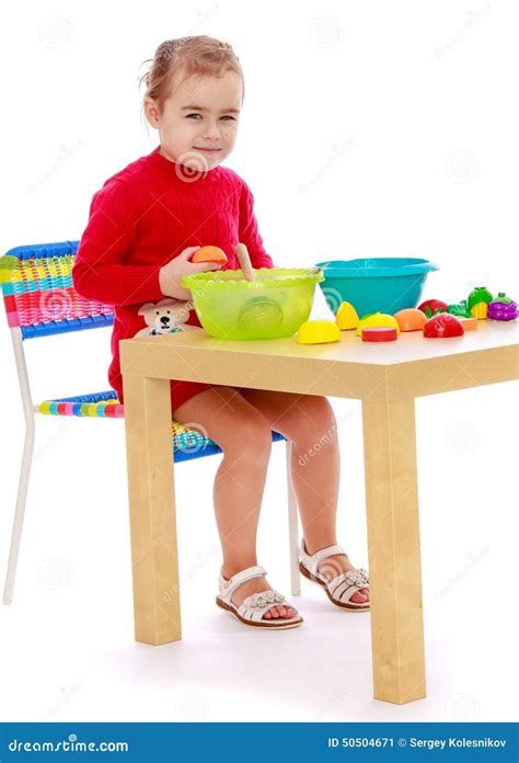 Smiling Child Sitting At The Table And Play Stock Image - Image: 50504671