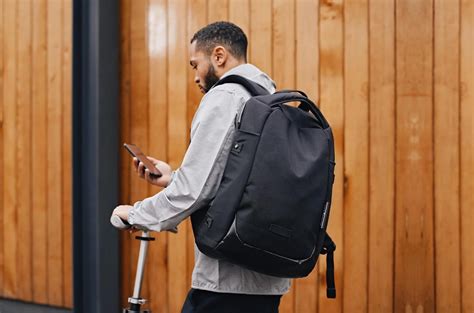 Traveler using anti-theft travel tips with secure backpack in busy city