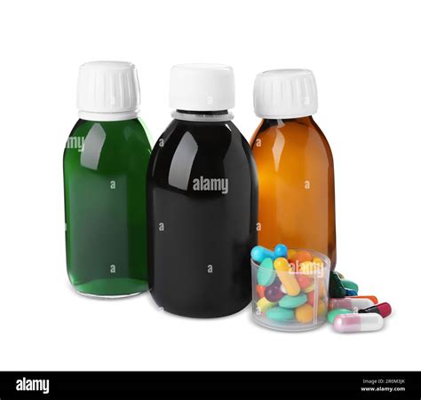Bottles of syrups, measuring cup with pills on white background. Cough ...