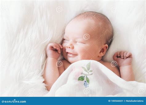 Sleeping Smiling Newborn Baby in a Wrap on White Blanket. Stock Image ...