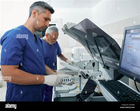 Laboratory assistants loading blood samples into biochemical automatic ...