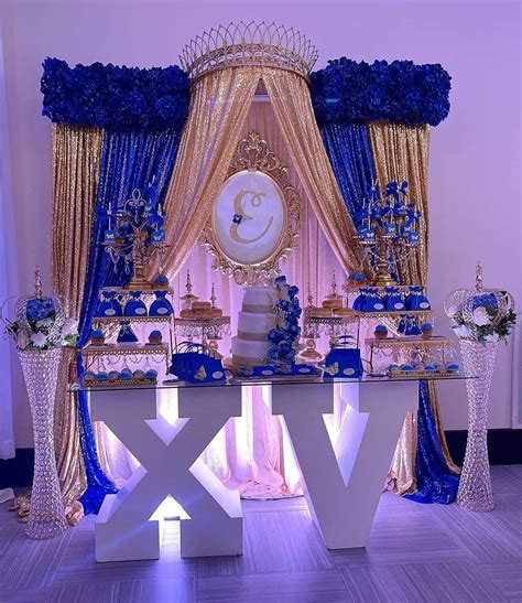 a table with blue and gold decorations in front of a large sign that ...
