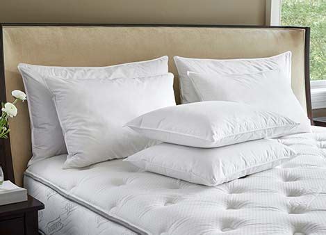 JW Marriott bed in hotel room with logo on an accent pillow