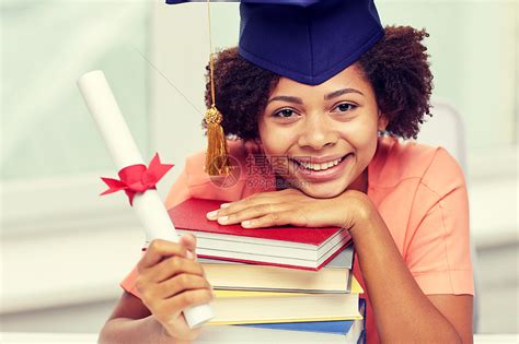 教育,学校,知识,毕业人的快乐的微笑非裔美国学生女孩戴着学士帽,书文凭坐家里的桌子上高清图片下载-正版图片300602321-摄图网