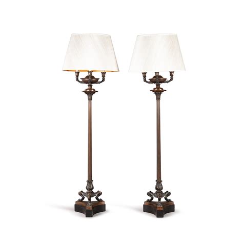 A pair of Restauration style patinated-bronze three-light floor lamps ...