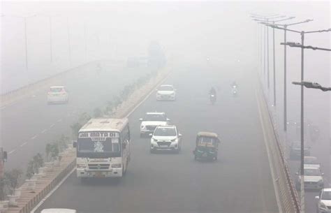 Vehicles navigate through dense fog on a chilly winter morning