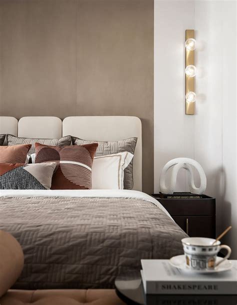 a bedroom with a bed, night stand and side table in front of the headboard