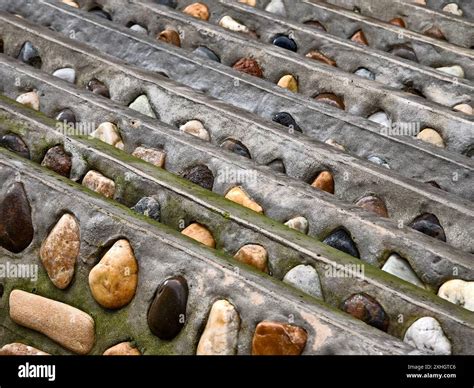 A pile of concrete tiles filled with rocks on top Stock Photo - Alamy
