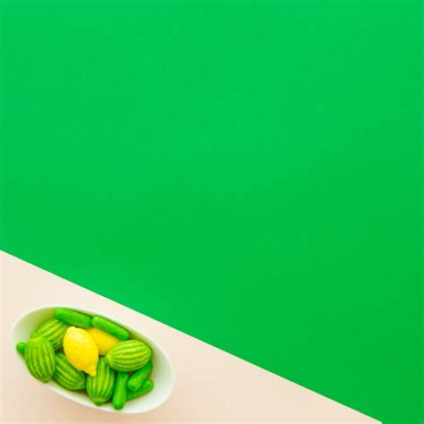 Different type of candies in bowl on multi colored background | Free Photo