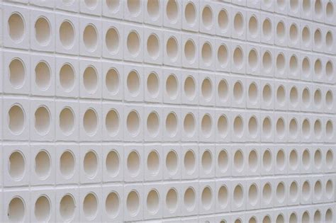 White ventilation block wall background with circle pattern in modern ...