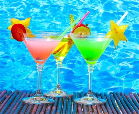 Glasses of cocktails on table on blue sea background | Premium Photo