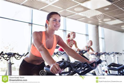 Group Of Women Riding On Exercise Bike In Gym Stock Photo - Image: 49311493