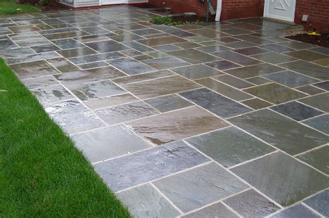 grey stone floor patio and green grass yard also white wooden wall ...