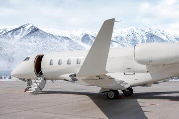Modern white private jet with opened gangway door at airport on ...