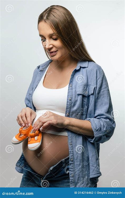 Pregnant Woman with Big Belly Showing Orange Cute Baby Shoes Stock ...